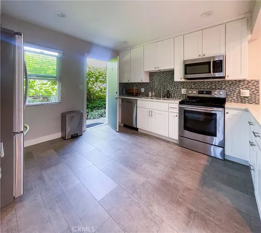 a kitchen with granite countertop a stove a sink and a microwave
