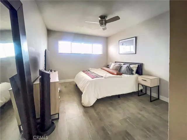 a bedroom with a bed a mirror and a window