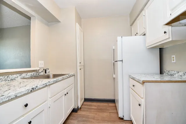 a spacious bathroom with a granite countertop sink and a mirror