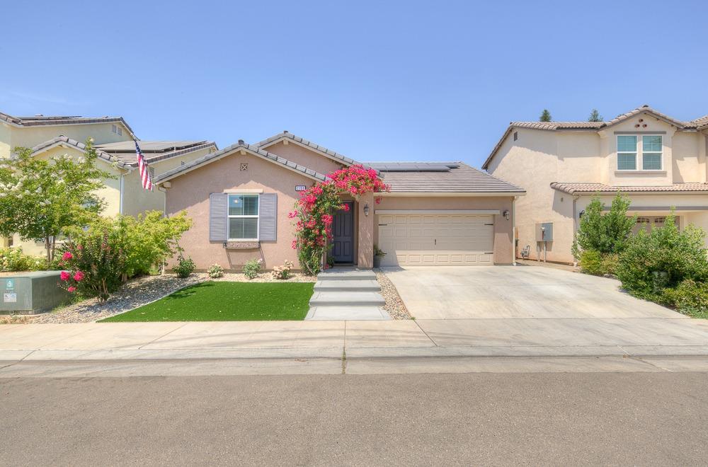 a front view of a house with a garden and plants