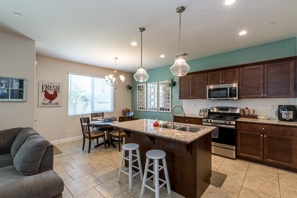 2731 Griffith Avenue Clovis, CA 93611 - Photo 17 of 34 a kitchen with stainless steel appliances granite countertop a stove a sink a microwave a center island and a cabinets