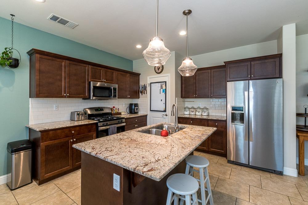 2731 Griffith Avenue Clovis, CA 93611 - Photo 19 of 34 a kitchen with stainless steel appliances granite countertop a stove refrigerator and microwave