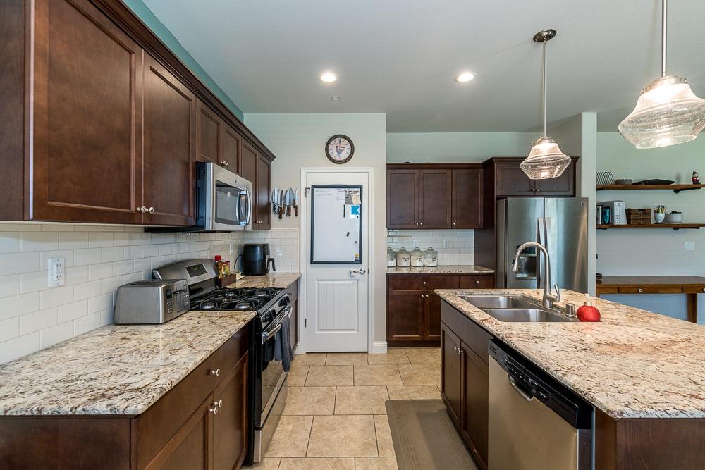 2731 Griffith Avenue Clovis, CA 93611 - Photo 20 of 34 a kitchen with stainless steel appliances granite countertop a sink stove and refrigerator
