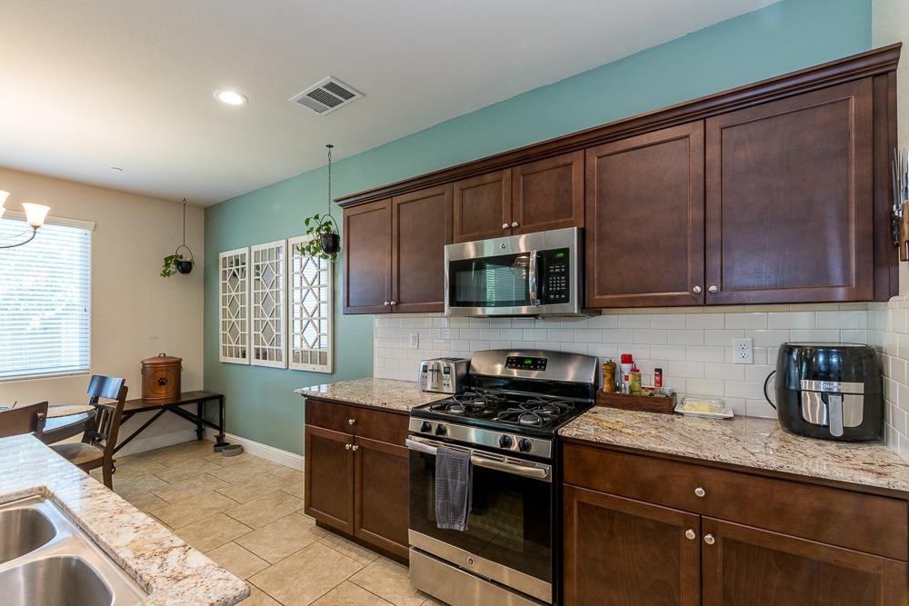 2731 Griffith Avenue Clovis, CA 93611 - Photo 23 of 34 a kitchen with stainless steel appliances granite countertop a sink stove and microwave