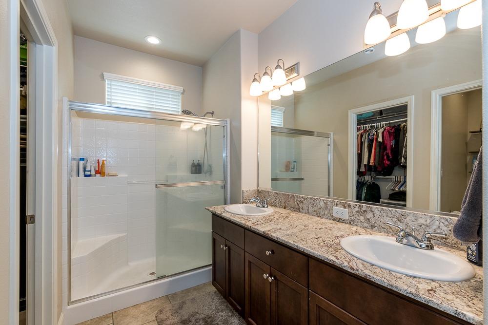 2731 Griffith Avenue Clovis, CA 93611 - Photo 28 of 34 a bathroom with a granite countertop sink shower and a mirror