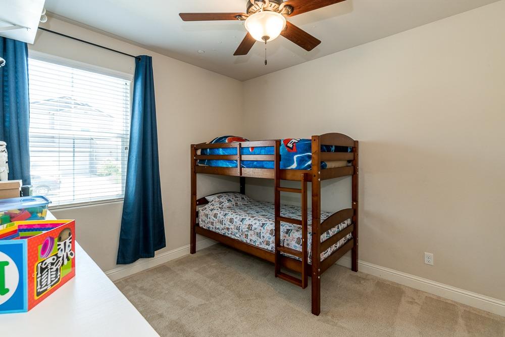 2731 Griffith Avenue Clovis, CA 93611 - Photo 29 of 34 a bedroom with a bed and a chandelier