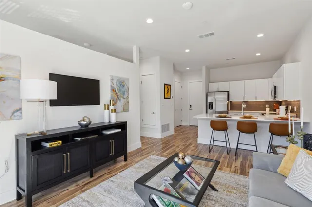 a living room with lots of furniture and kitchen view