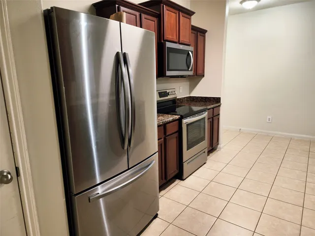 a kitchen with stainless steel appliances a refrigerator sink and microwave