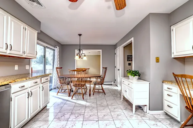 a dining room with stainless steel appliances a dining table and chairs