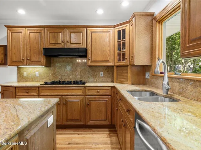 a kitchen with granite countertop a sink stove and cabinets