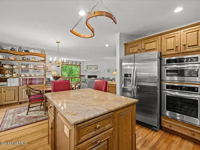 a kitchen with stainless steel appliances granite countertop a sink and a refrigerator
