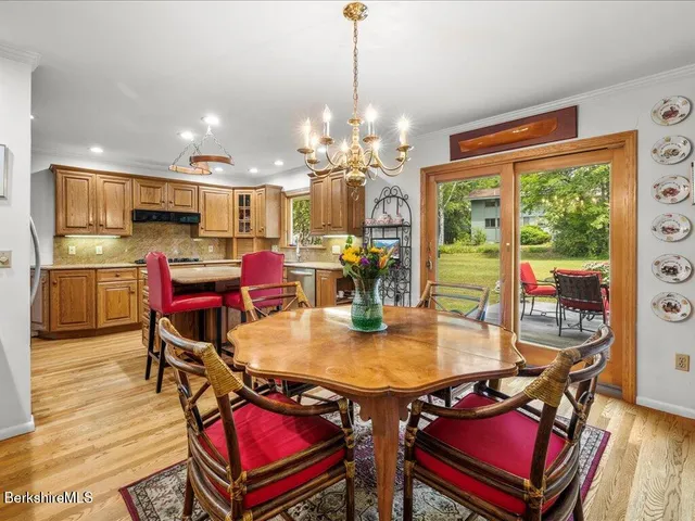 a view of a dining room with furniture a chandelier and wooden floor