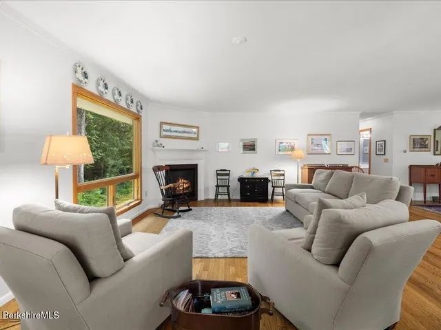 a living room with furniture fireplace and a large window