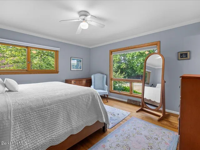a spacious bedroom with a bed a chandelier and a large window