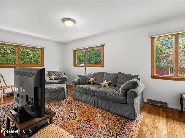 a living room with furniture a window and a flat screen tv