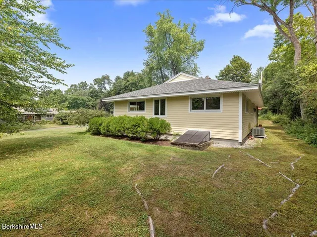 a view of a swimming pool with lawn chairs under an umbrella