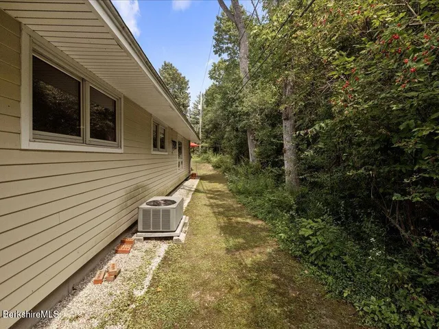 a view of a swimming pool with lawn chairs and plants