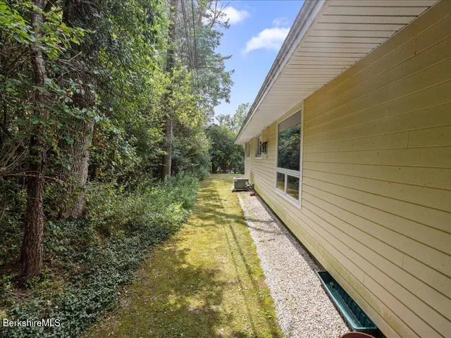 a view of a house with yard and basketball ground