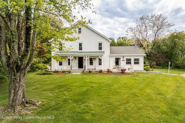 a front view of house with yard seating and green space