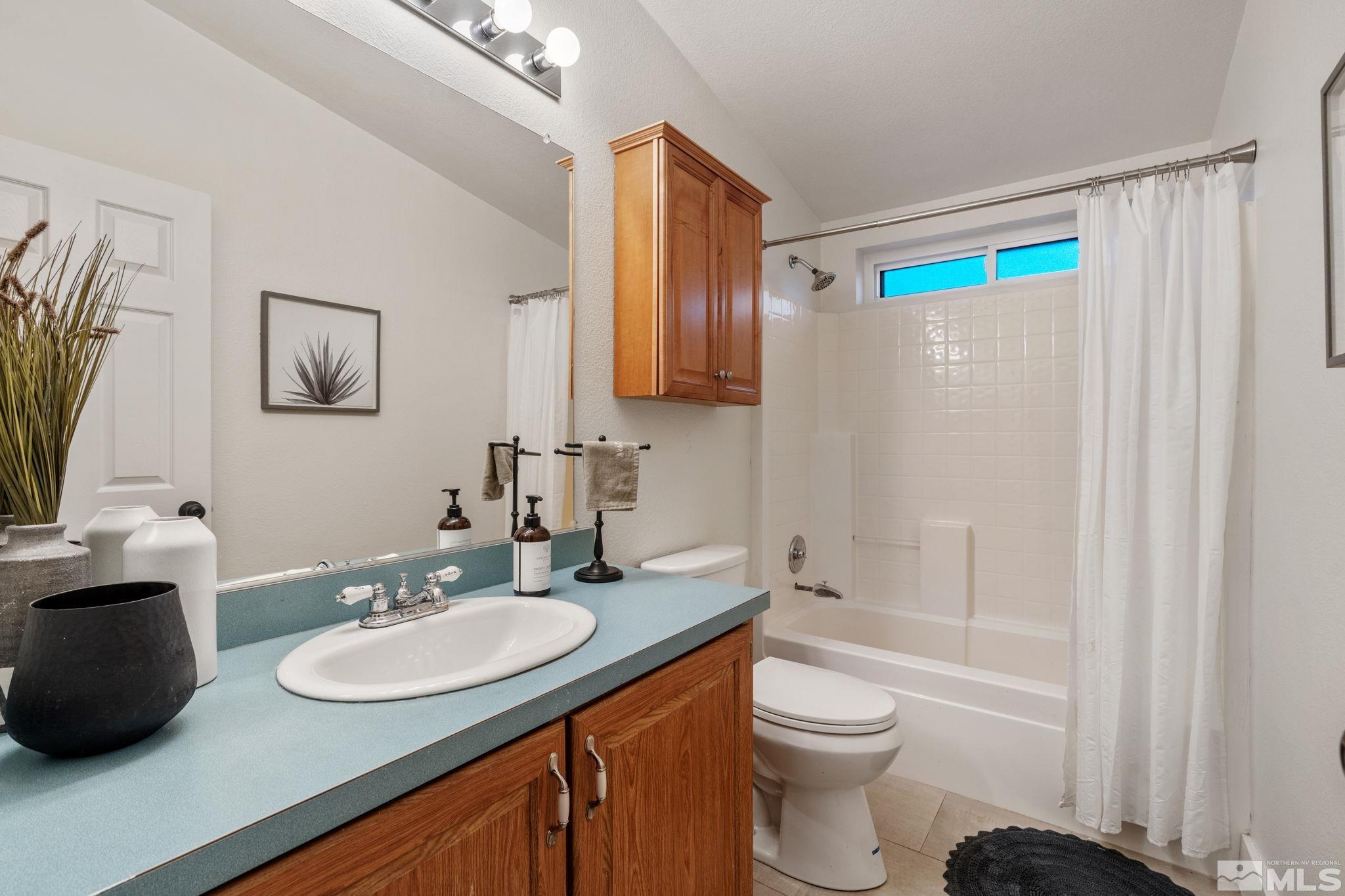 1327 Lynx Street Reno, NV 89506 - Photo 33 of 38 a bathroom with a toilet a sink and a mirror