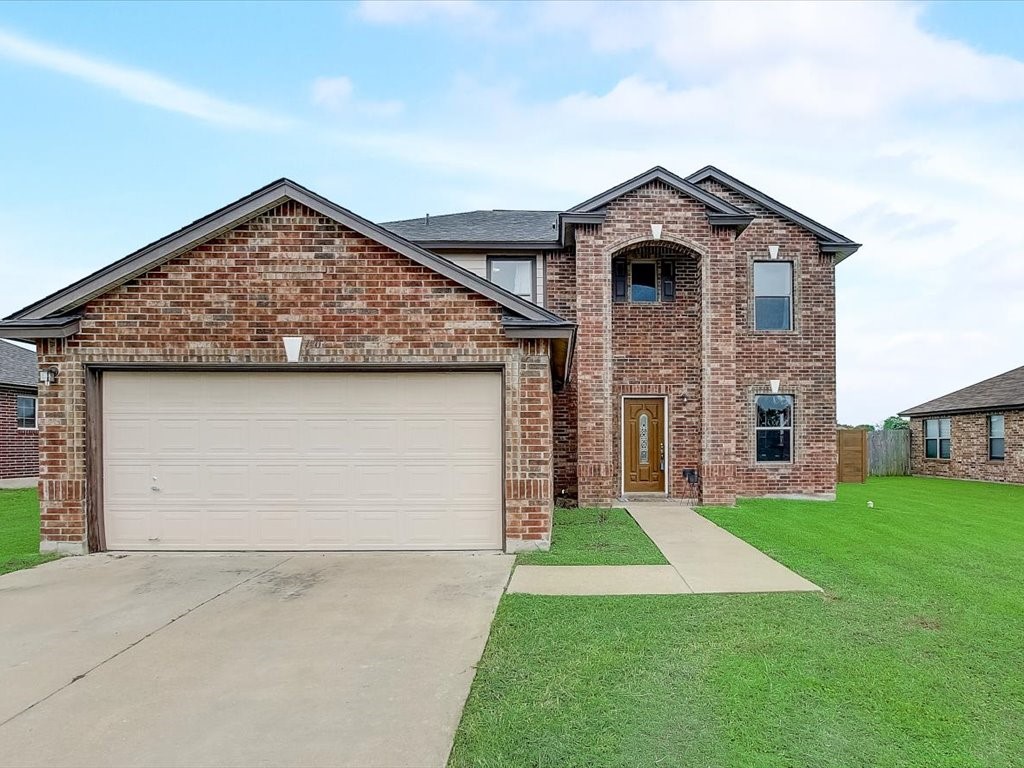 a front view of a house with a yard and garage
