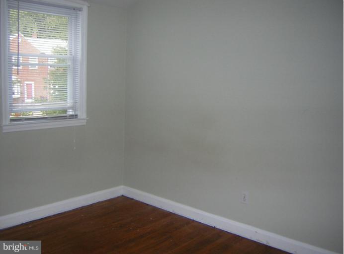 1677 Thetford Road Towson, MD 21286 - Photo 12 of 18 a view of an empty room with wooden floor and a window