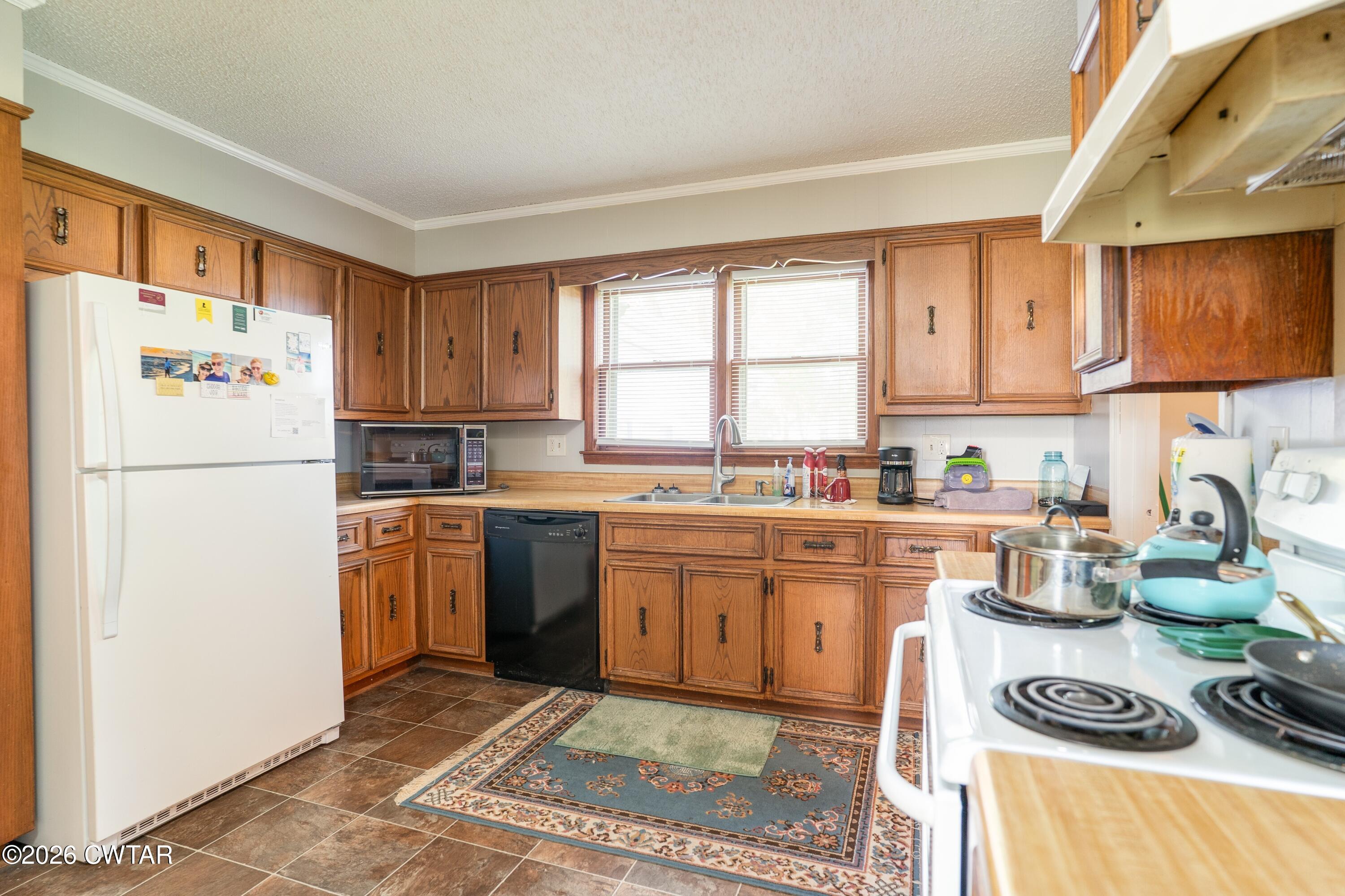 1053 Ashport Road Jackson, TN 38305 - Photo 24 of 42 a kitchen with a refrigerator a stove a sink and cabinets