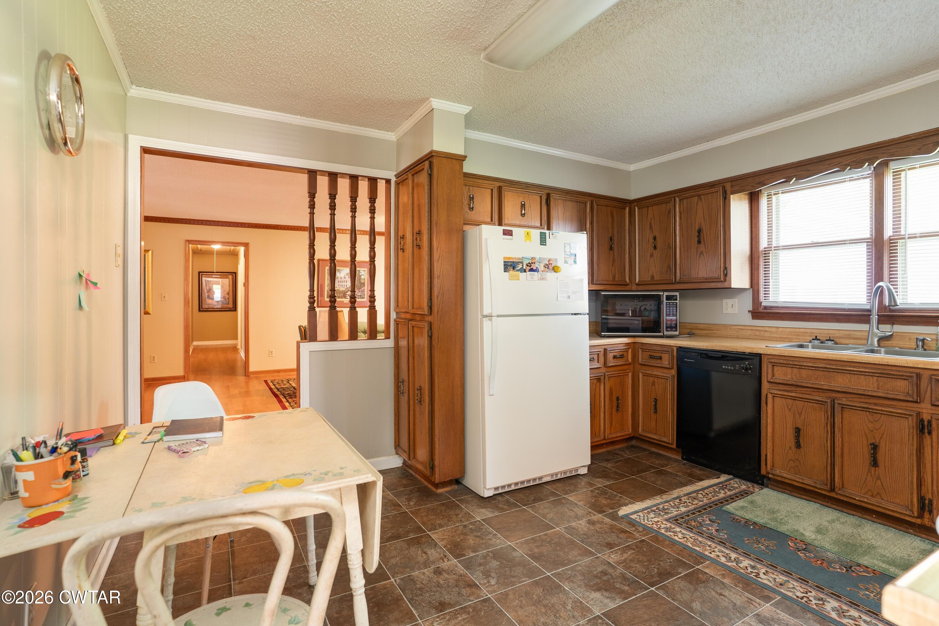 1053 Ashport Road Jackson, TN 38305 - Photo 25 of 42 a kitchen with a refrigerator a sink dishwasher with a dining table and chairs