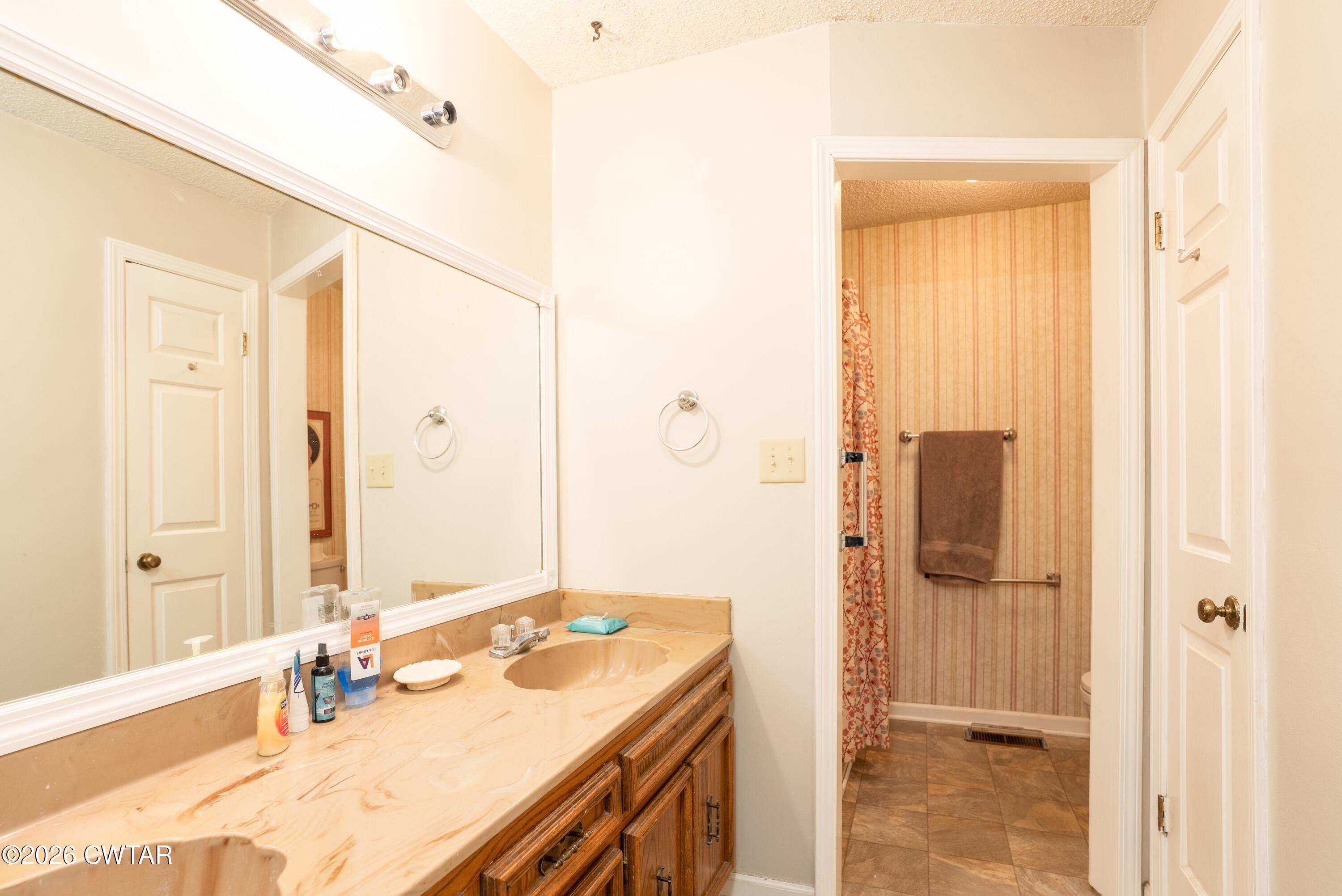 1053 Ashport Road Jackson, TN 38305 - Photo 29 of 42 a bathroom with a granite countertop sink and a mirror