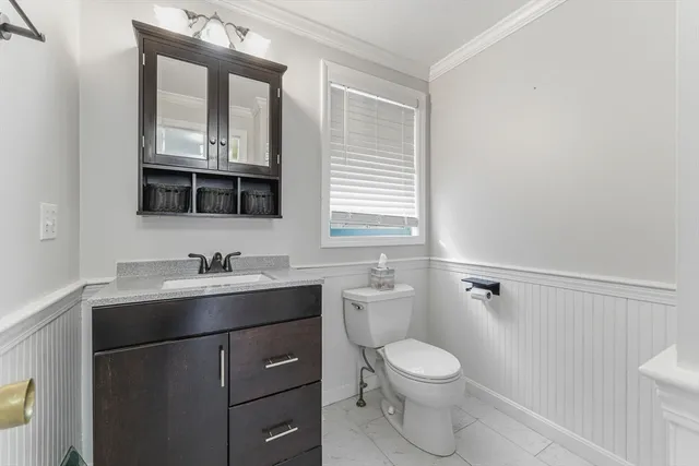 a bathroom with a toilet a sink a vanity and mirror