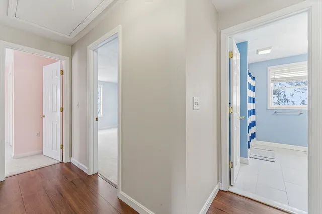 a view of a hallway with wooden floor and closet