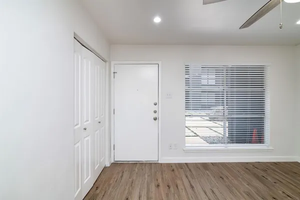 a view of a hallway with wooden floor and a window