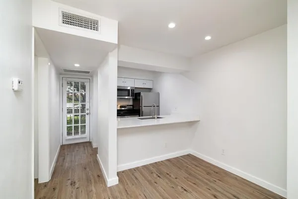 a view of kitchen with wooden floor and electronic appliances