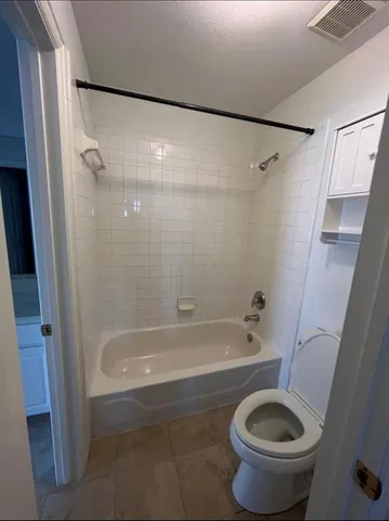 a bath room with a toilet and a bath tub