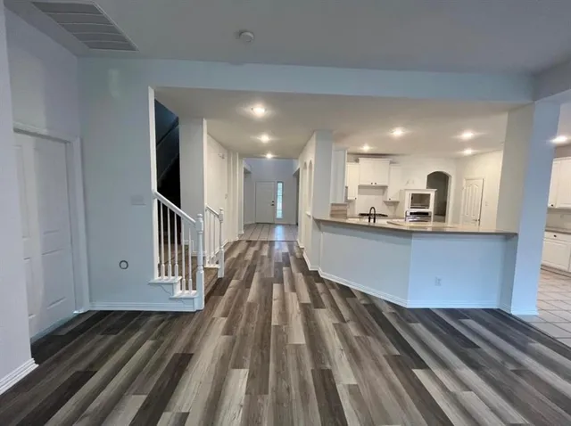 a view of kitchen with wooden floor and electronic appliances
