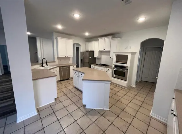a kitchen with refrigerator and cabinets