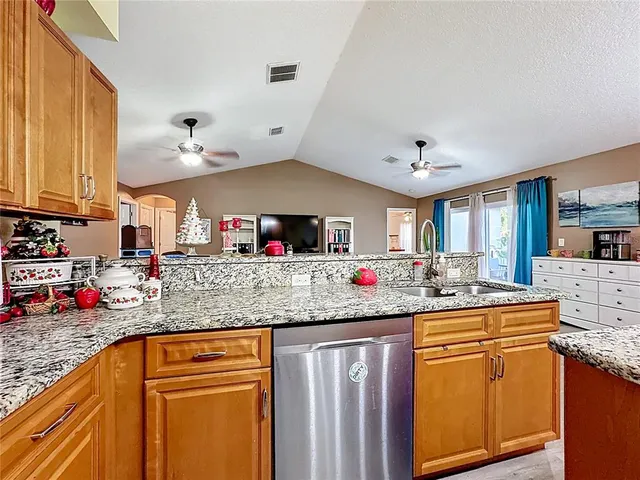 a kitchen with granite countertop a sink and cabinets