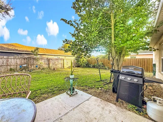 a backyard of a house with table and chairs