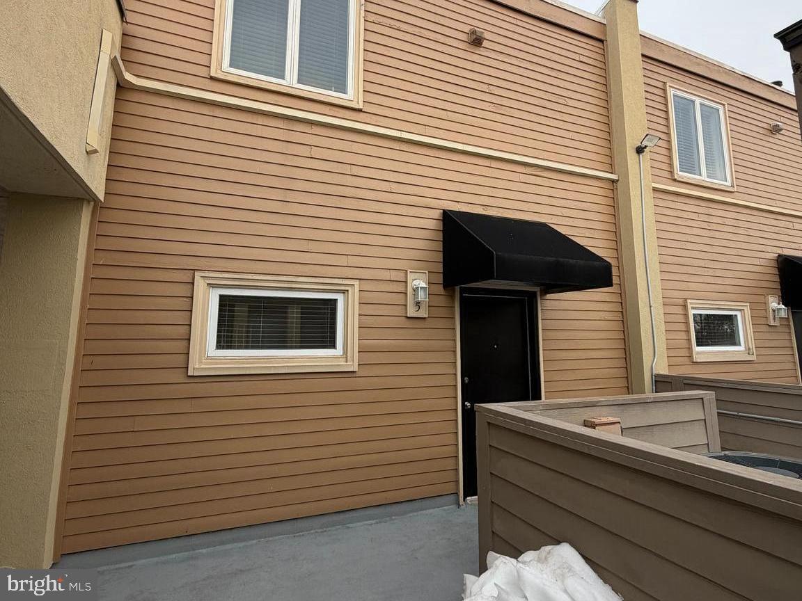 a view of a house with a door and a tree