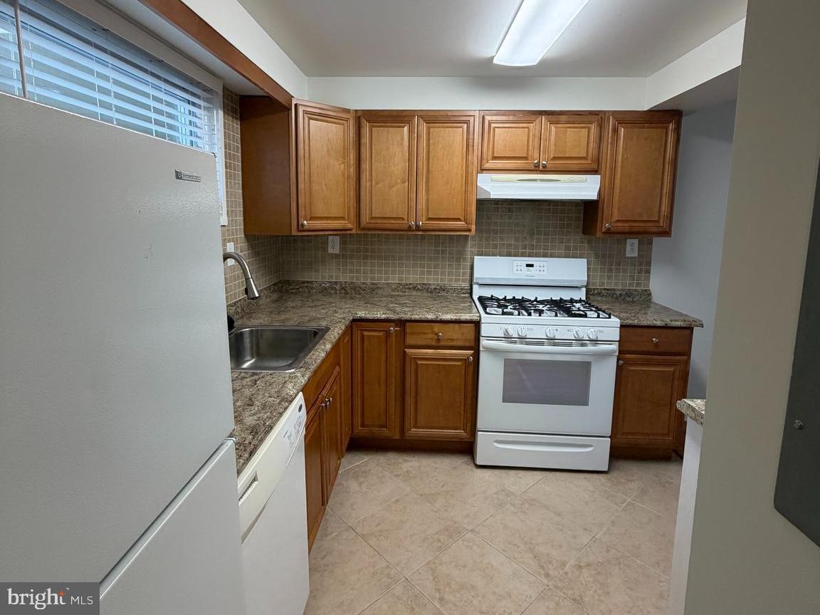 5485 Harpers Farm Road, Unit L5 Columbia, MD 21044 - Photo 7 of 17 a kitchen with a stove sink and cabinets