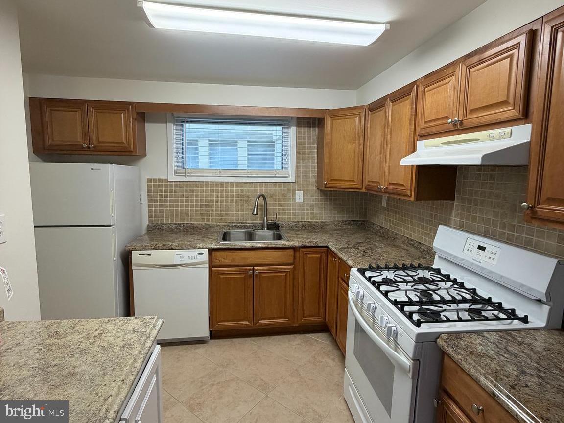5485 Harpers Farm Road, Unit L5 Columbia, MD 21044 - Photo 8 of 17 a kitchen with stainless steel appliances granite countertop a sink stove and refrigerator