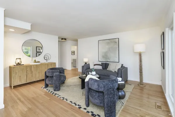 a living room with furniture a dining table and wooden floor