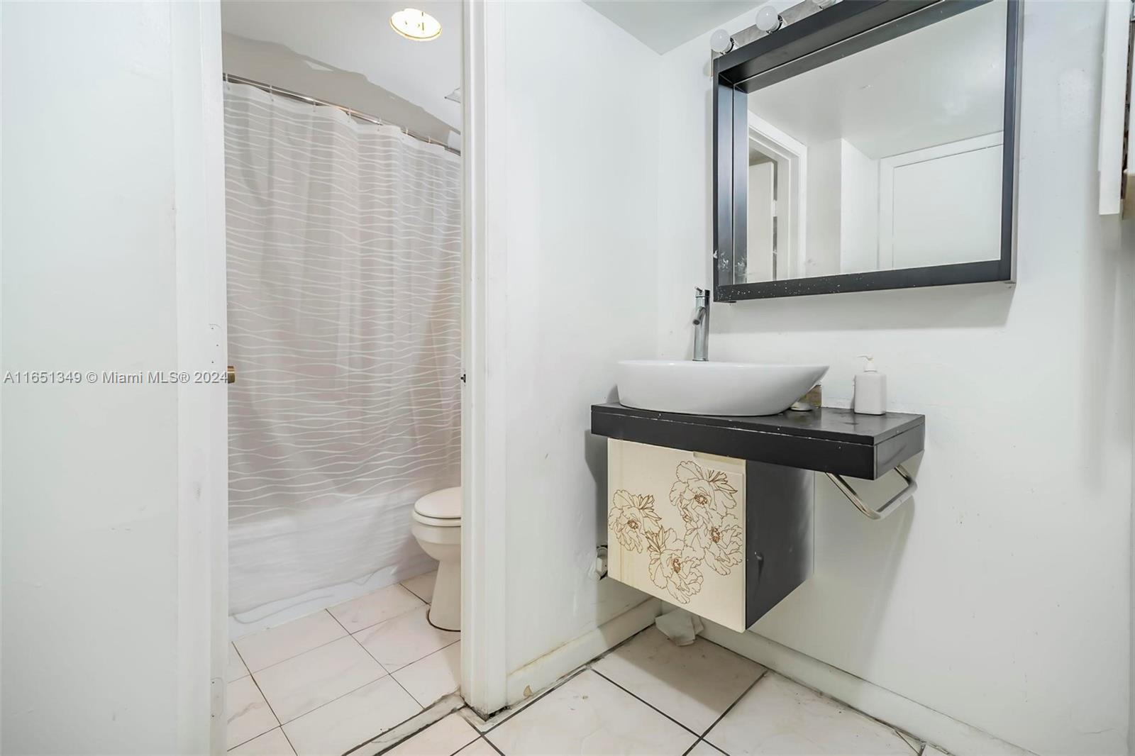 9823 Southwest 138th Avenue, Unit FC2L Miami, FL 33186 - Photo 12 of 28 a bathroom with a toilet sink and mirror