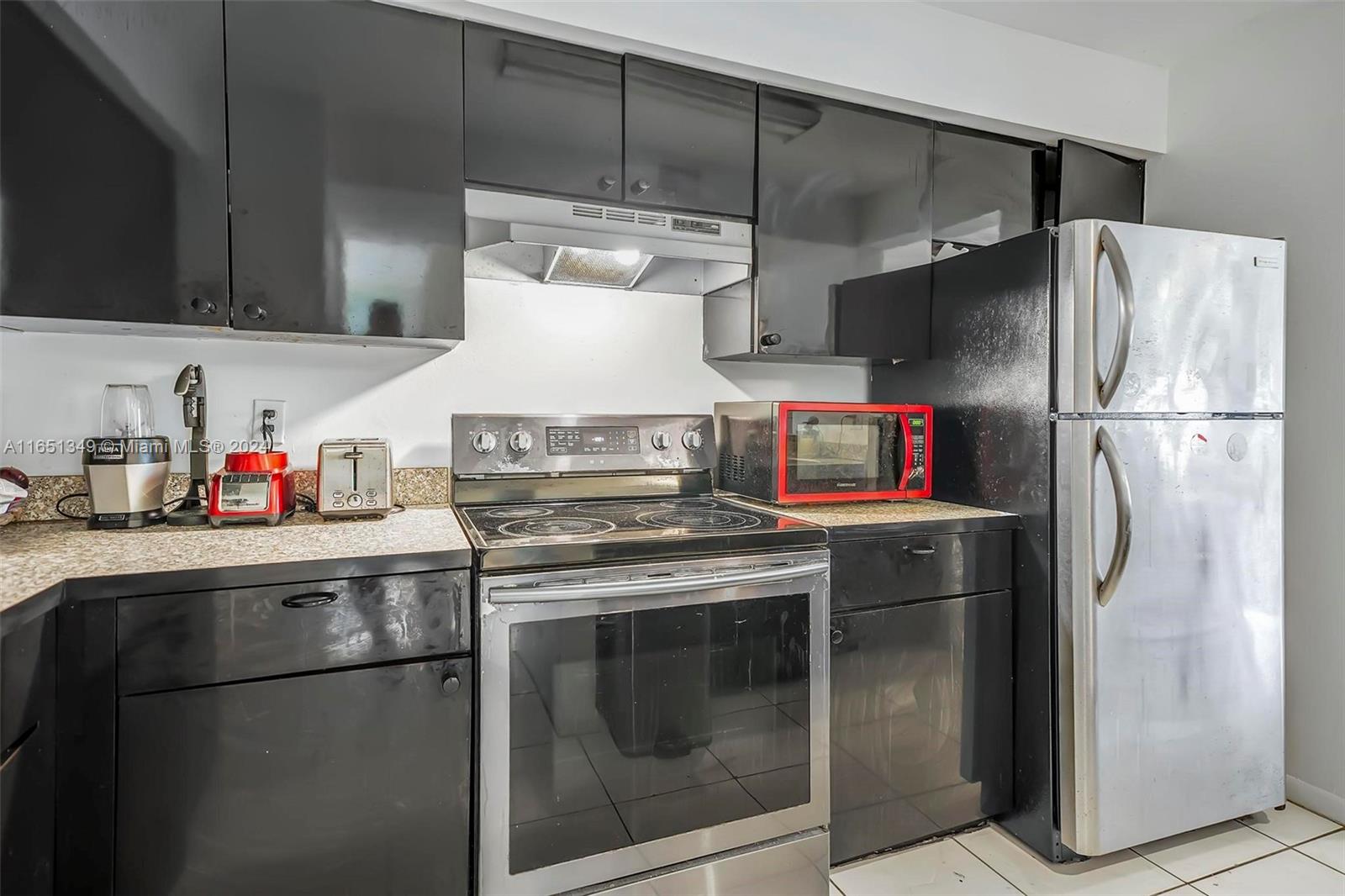 9823 Southwest 138th Avenue, Unit FC2L Miami, FL 33186 - Photo 16 of 28 a kitchen with stainless steel appliances granite countertop a refrigerator and a stove