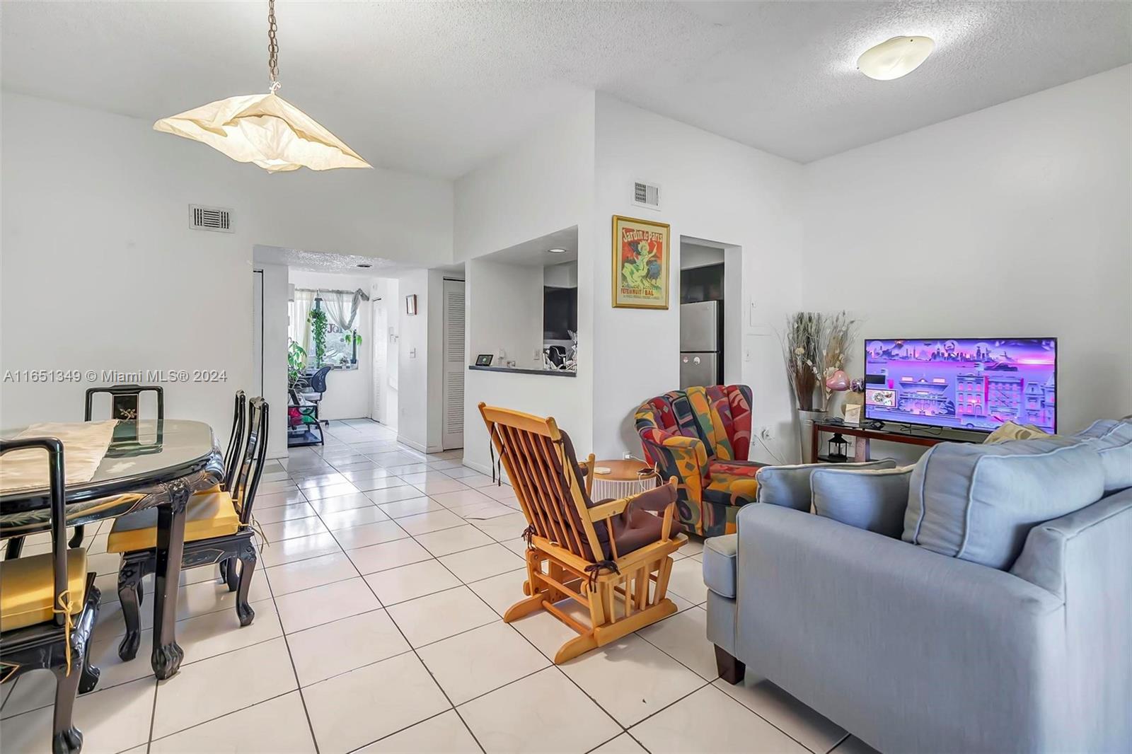 9823 Southwest 138th Avenue, Unit FC2L Miami, FL 33186 - Photo 3 of 28 a living room with furniture a dining table and a mirror