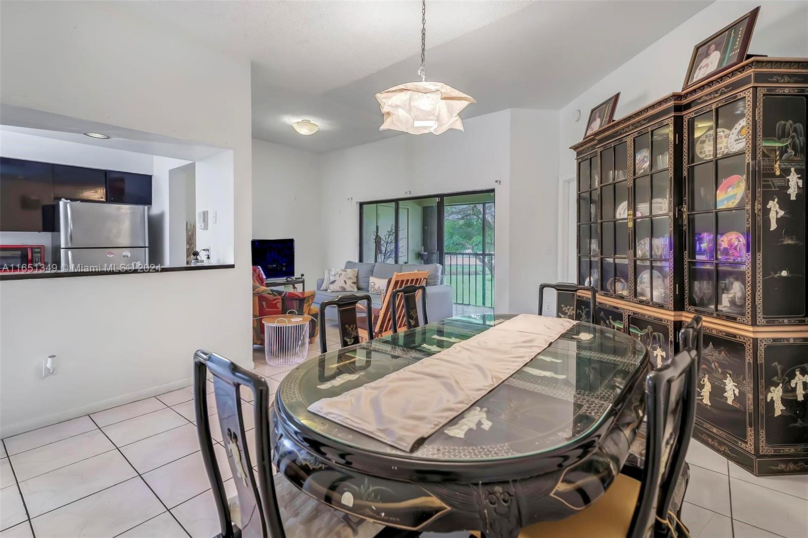 9823 Southwest 138th Avenue, Unit FC2L Miami, FL 33186 - Photo 5 of 28 a view of a dining room with furniture and chandelier