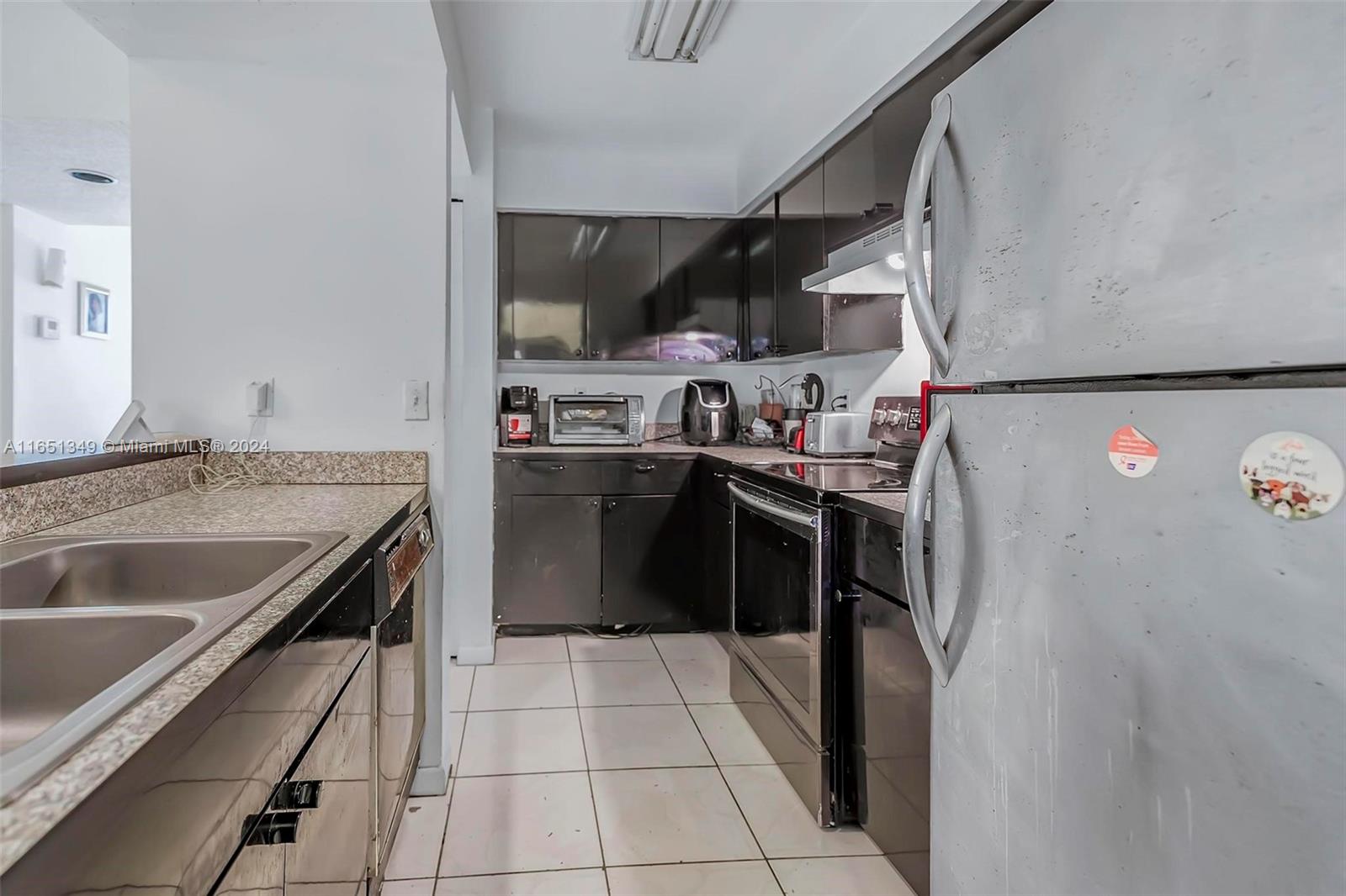 9823 Southwest 138th Avenue, Unit FC2L Miami, FL 33186 - Photo 6 of 28 a kitchen with stainless steel appliances granite countertop a sink stove and refrigerator