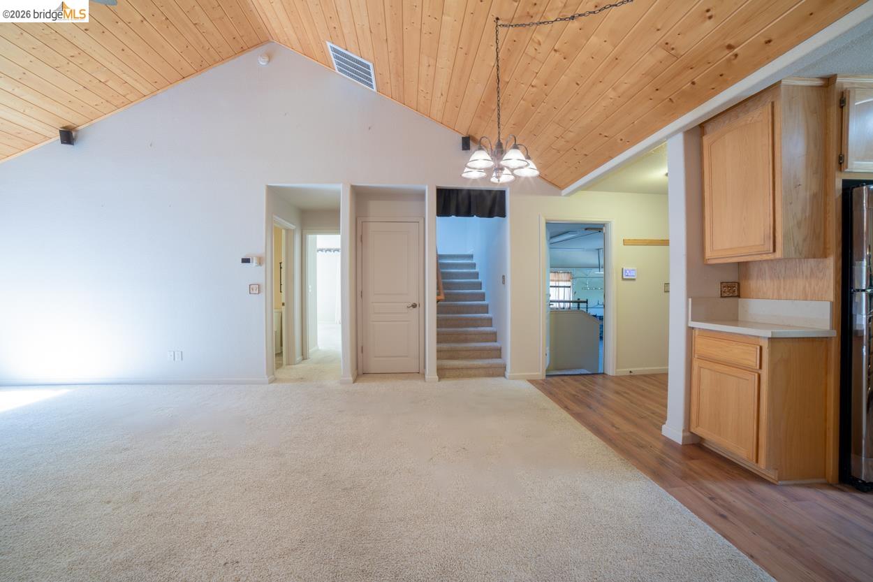 22401 Ridge Road Twain Harte, CA 95383 - Photo 19 of 52 Vaulted wood-paneled ceiling, light-toned carpeting, wood-finish flooring, built-in cabinetry, and a multi-light pendant fixture