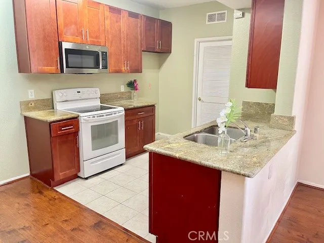 a kitchen with stainless steel appliances granite countertop a sink stove and microwave