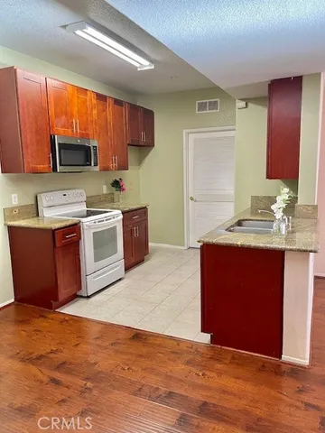a kitchen with stainless steel appliances kitchen island granite countertop a stove a sink and a microwave
